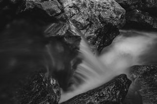 a black and white photo of rocks and water